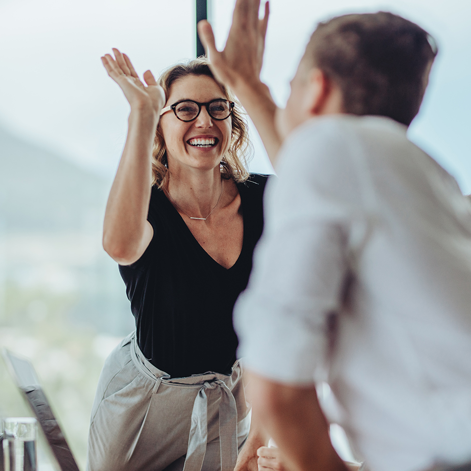 employees high fiving - Optometry Practice Growth in North America